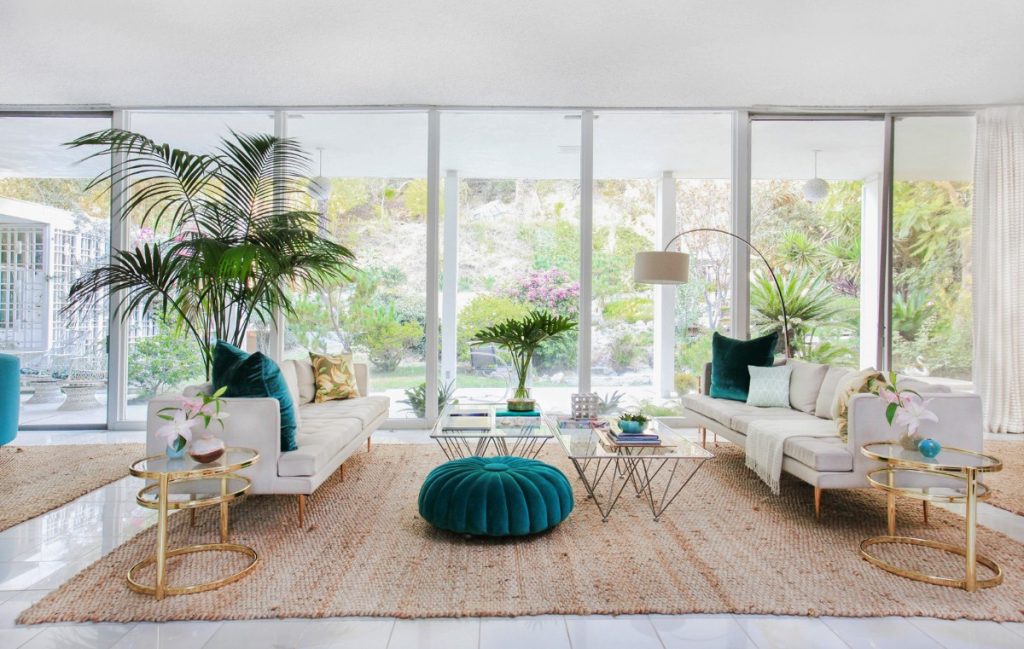 This room’s large windows allow flow between the green colors and palm shapes inside and out.