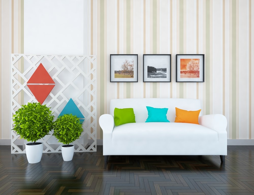 Pillows in solid colors complement the more complex art and plants adjacent to them. 